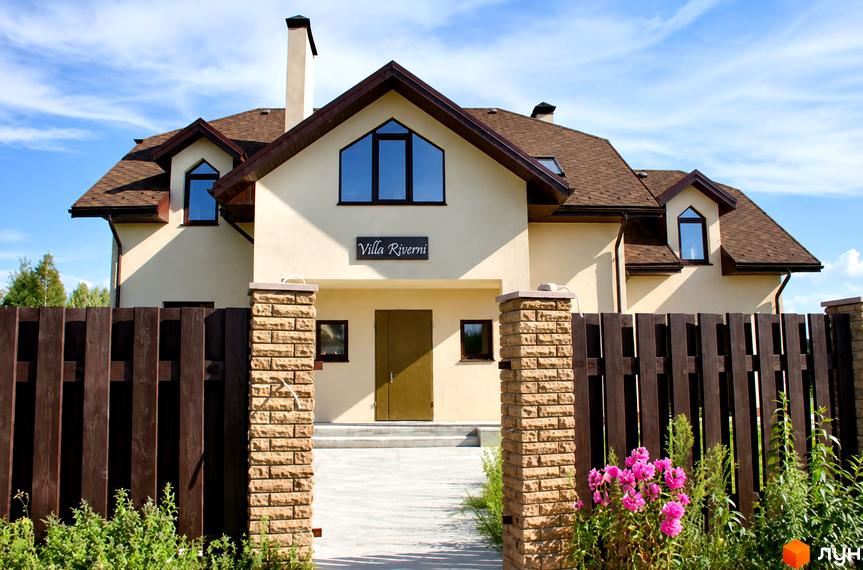 Котеджне містечко Swiss Village: двоповерховий будинок з бежевим фасадом, коричневим дахом та огородженою прибудинковою територією.