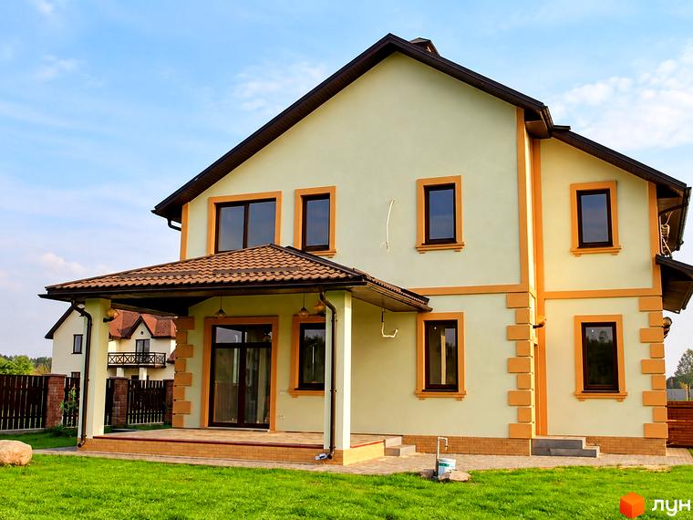 Котеджне містечко Swiss Village: двоповерховий будинок з бежевим фасадом, терасою та доглянутим газоном перед ним.