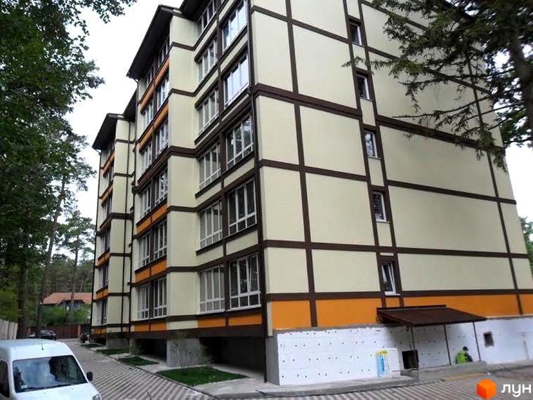 Зображення фасаду Житлового комплексу Яснополянський. Багатоповерховий будинок з великими вікнами та оздобленим фасадом, поруч зелені насадження.