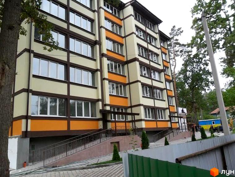 Зображення фасаду багатоквартирного будинку в Житловому комплексі Яснополянський. На фото видно прибудинкову територію та зелені насадження.