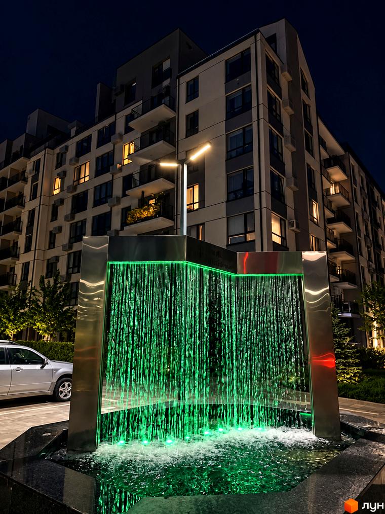 Житловий комплекс Park Residence з багатоповерховим будинком. На території розташований декоративний водоспад із зеленим підсвічуванням.
