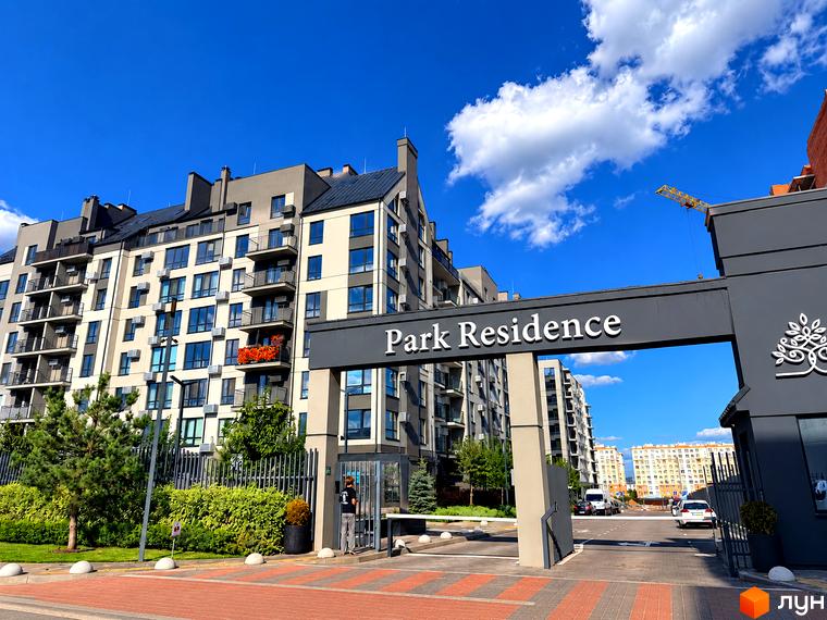 Житловий комплекс Park Residence з під'їзною групою та воротами на прибудинковій території з декоративними рослинами.