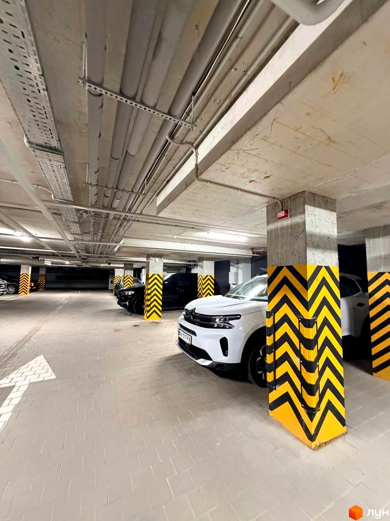 Підземний паркінг у ЖК Park Residence з розміткою та припаркованими автомобілями. Просторе місце для авто.