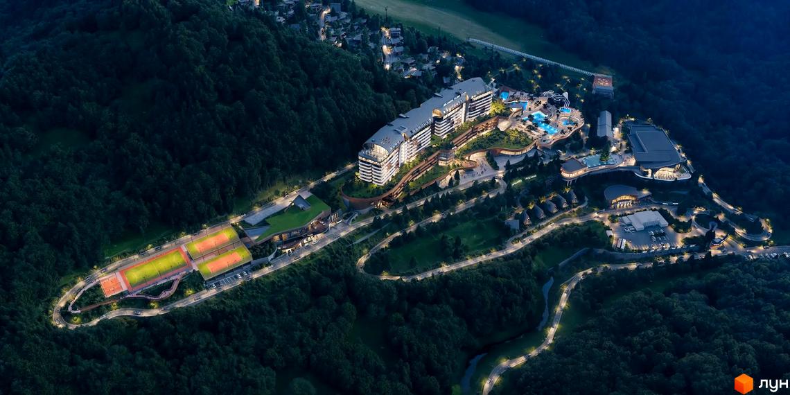 Нічний вигляд комплексу Apartel Polyana з підсвічуванням будівель, спортивними майданчиками та басейнами.