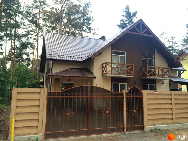 Фото будинку на вулиці Патона. Огороджена територія з кованими воротами та дерев'яним парканом.