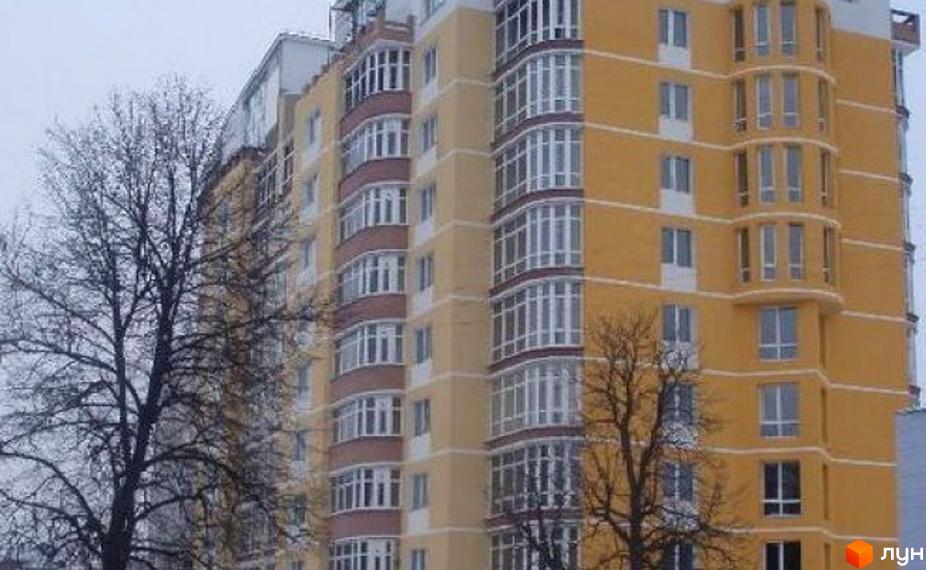 Житловий комплекс на вул. Берестовська (Пушкіна), 22. Багатоповерховий будинок з жовтим фасадом та еркерними елементами, оточений голими деревами.