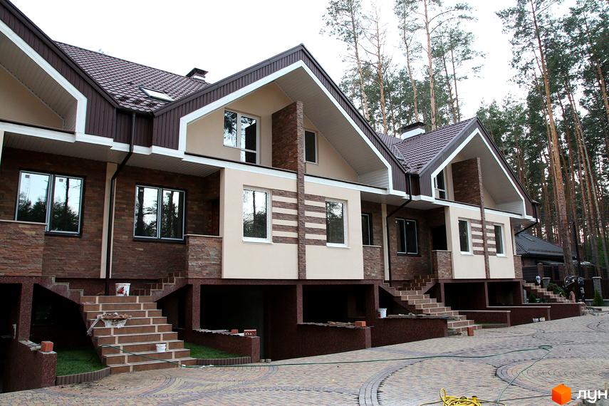 Сучасний житловий комплекс на вулиці Гоголя, 12в. Фасад оздоблений каменем та штукатуркою, з великими вікнами. Прибудинкова територія вимощена бруківкою.