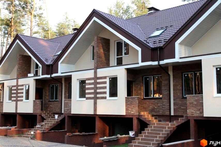 Зовнішній вигляд новобудови на вул. Гоголя, 12в. Фасад оздоблений цеглою та штукатуркою, з коричневим дахом та білими елементами. Перед будинком розташовані сходи та прибудинкова територія.