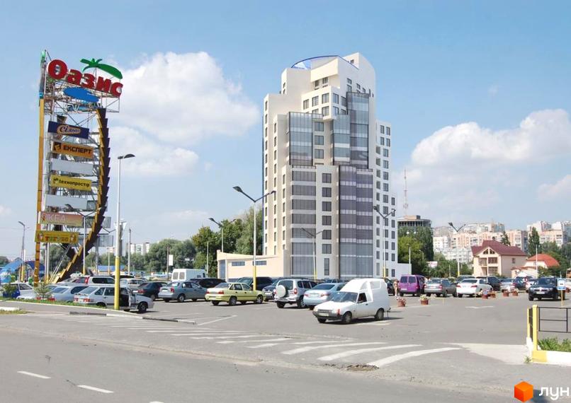 Новобудова на вул. Бандери (Рибалко), 2/1 з багатою прибудинковою територією та парковкою. Комплекс має багатоповерхову будівлю з сучасним фасадом та великою кількістю вікон.