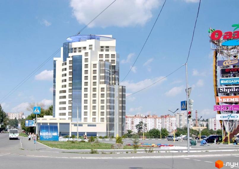 Новобудова на вулиці Бандери (Рибалко), 2/1. Біла висотна будівля з панорамними вікнами та скляними елементами, розташована біля дороги з пішохідним переходом та зеленими насадженнями.