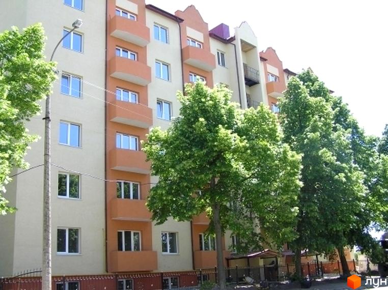 Новобудова на вулиці Ясна, 7б. Будинок з помаранчевими балконами та світлими стінами, оточений зеленими деревами.