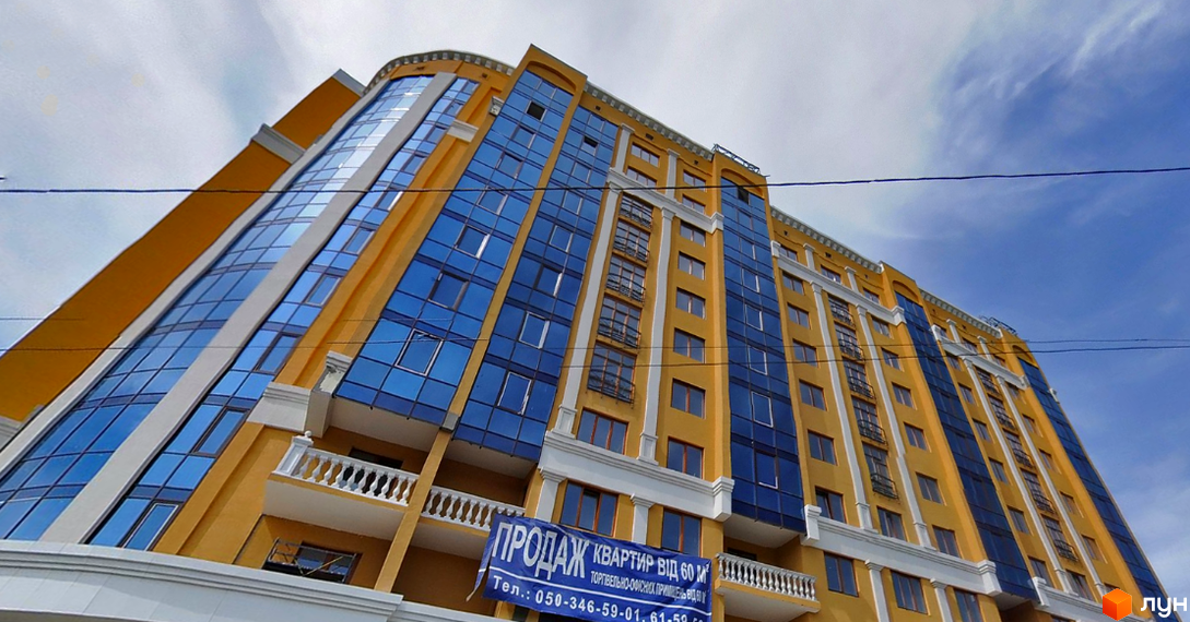 Житловий комплекс на вулиці Івана Банка (Коваля), 2, Київ. Фасад будівлі оздоблений жовтою штукатуркою та великими синіми вікнами, з білими декоративними елементами та балконами.