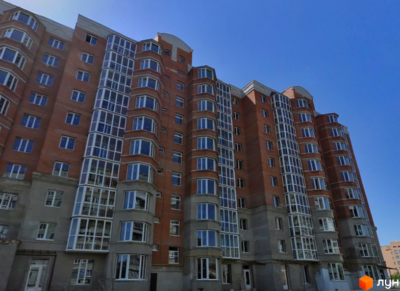 Багатоповерховий житловий будинок з червоної цегли та заскленими балконами на вул. Олександра Бідного, 20.