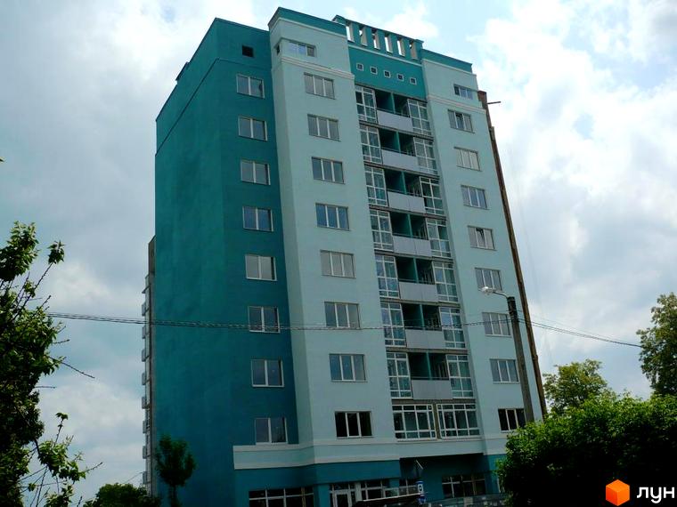 Багатоповерхова новобудова у відтінках блакитного на вул. Олександра Оксанченка (Степового Фронту), 18-28. Навколо видно дерева та небо.