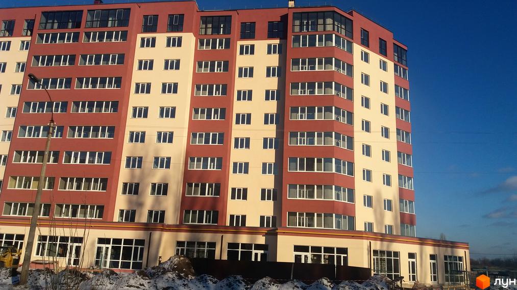 Житловий комплекс Другий Парковий: багатоповерхова новобудова з червоно-бежевим фасадом та великою кількістю вікон.