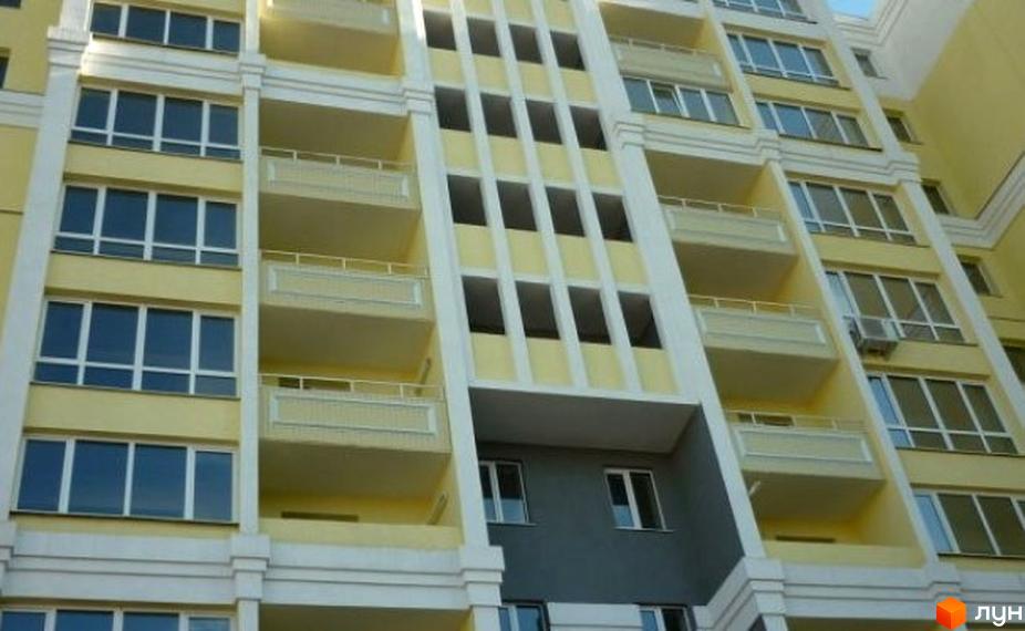 Фасад житлового комплексу просп. Перемоги, 119а, з численними балконами та вікнами. Зовнішній вигляд новобудови з жовтими стінами та білими декоративними елементами.