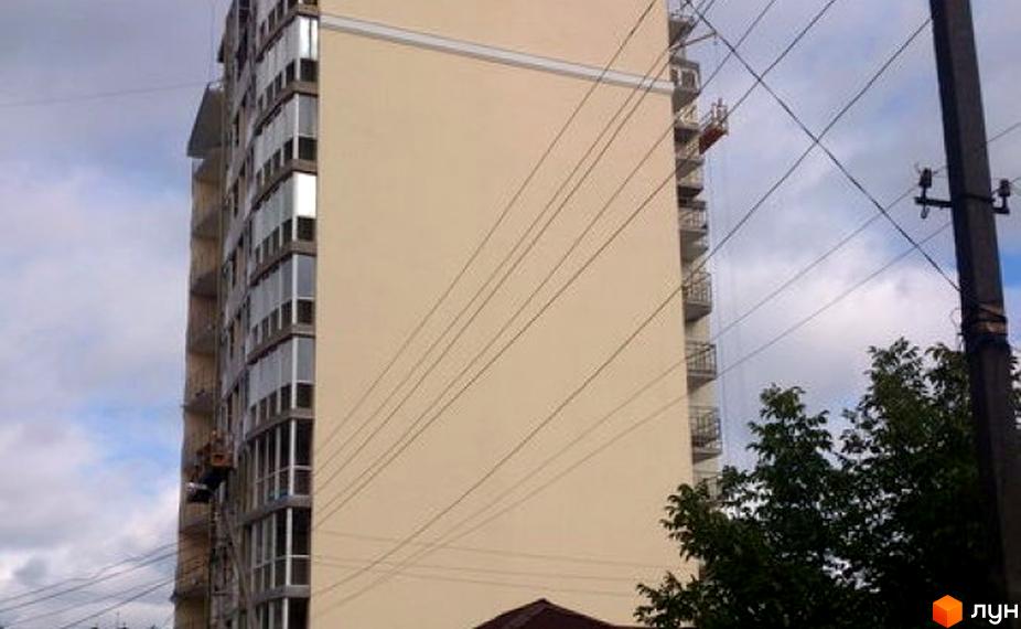 Фасад житлового комплексу на вулиці Національної Гвардії, 21. Будинок має багато вікон та балконів, оздоблений світлою штукатуркою. Навколо видно дерева та елементи міської інфраструктури.