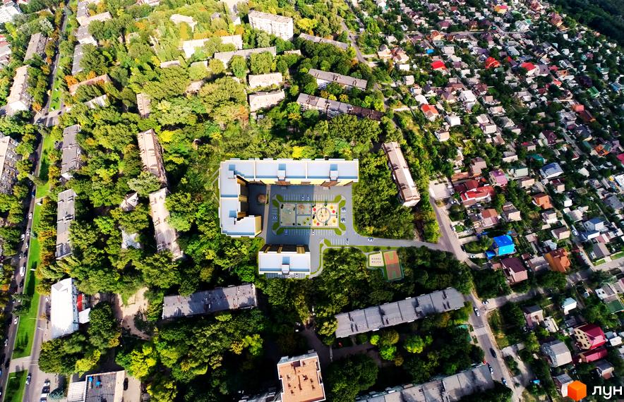 Аерофотозйомка житлового комплексу Сімейний з новою будівлею та дитячим майданчиком. Навколо зелені насадження та сусідні будинки.