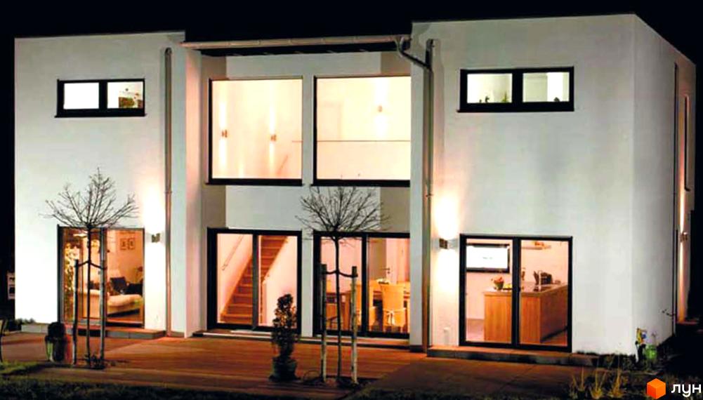 КМ Родзинка: двоповерховий будинок з великими вікнами та підсвіткою. Навколо будинку доглянута прибудинкова територія з деревами та освітленням.