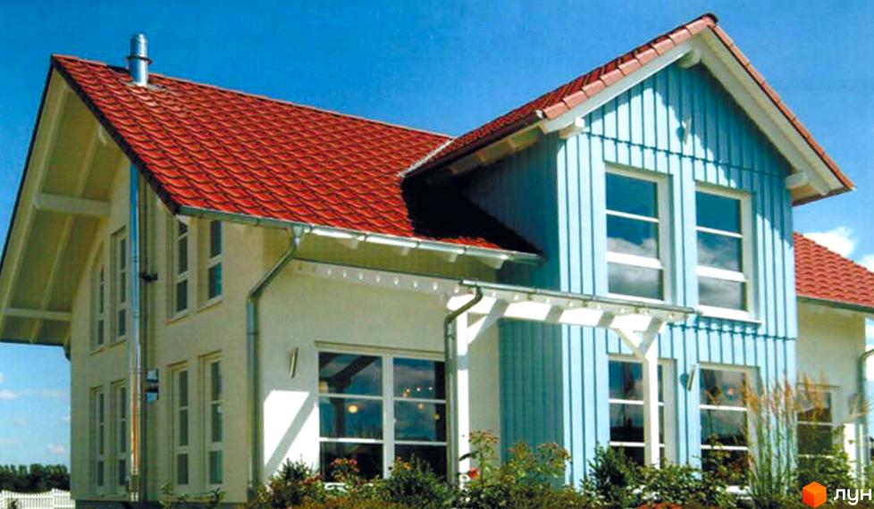 Котеджне містечко КМ Родзинка: двоповерховий будинок з червоним черепичним дахом та блакитними дерев'яними стінами, великими вікнами, на тлі блакитного неба. Навколо будинку зелені насадження та дерева.