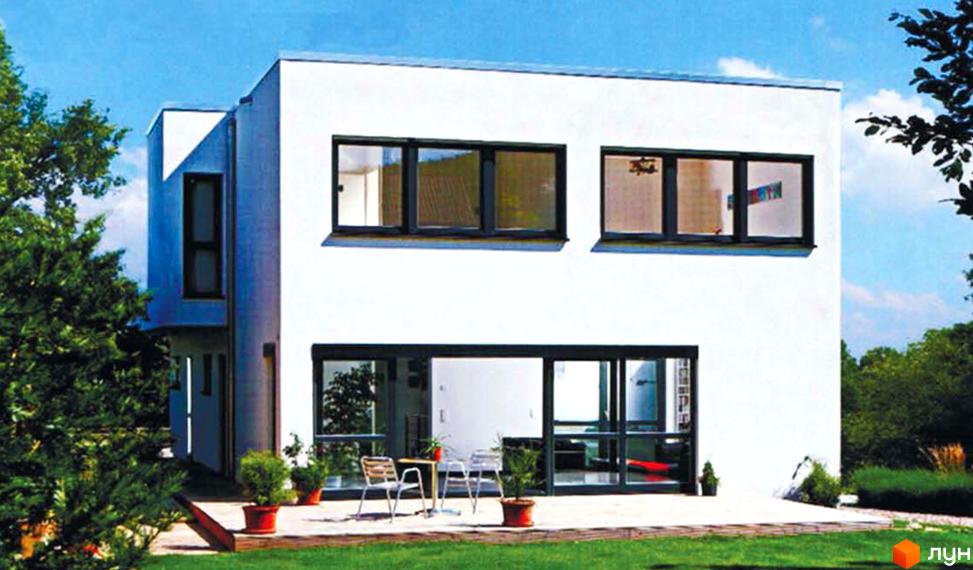 Котеджне містечко Родзинка: білий двоповерховий будинок з великими вікнами та терасою. Навколо будинку зелений газон та дерева.