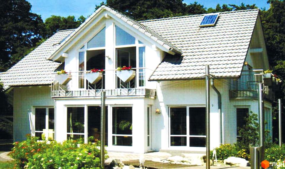 Котеджне містечко Родзинка: білий двоповерховий будинок з великими вікнами, балконом та доглянутою зеленню навколо. На даху встановлено сонячну панель.