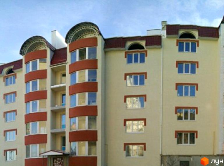 Фасад житлового комплексу на вулиці Буковинській, 14. Багатоповерховий будинок з червоним дахом та коричневими декоративними елементами навколо вікон.