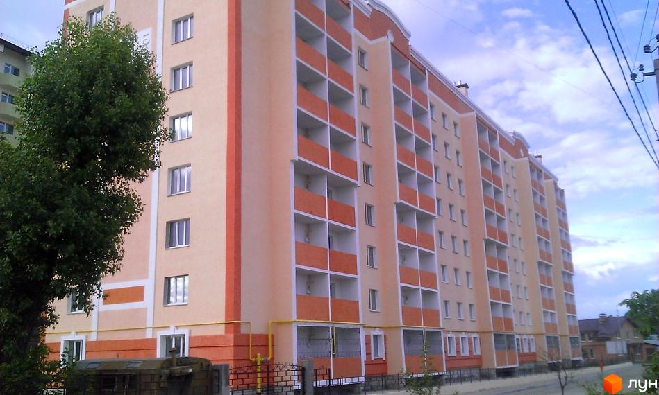 Зображення фасаду багатоповерхового будинку в Житловому комплексі Новокиївський. На фото видно балкони та вікна, а також частину прибудинкової території.