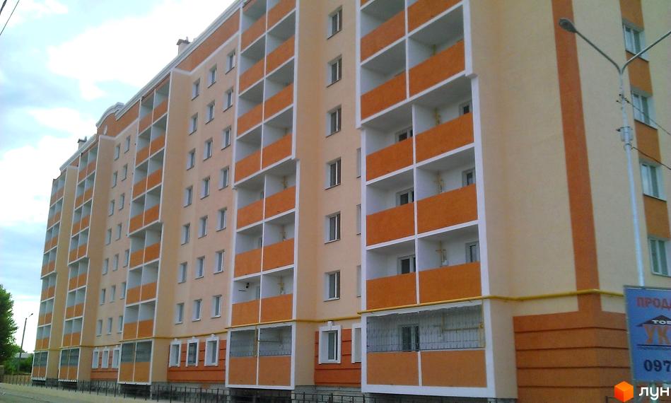 Зовнішній вигляд Житлового комплексу Новокиївський. Багатоповерховий будинок з балконами, пофарбований у світлі кольори.