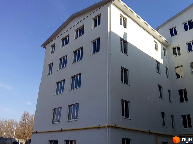 Зовнішній вигляд будинку на вулиці Велика кільцева, 4. Багатоповерхова будівля з великою кількістю вікон та світлим фасадом.