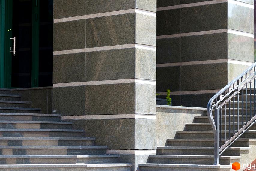 Вхідна група житлового комплексу Зелена тераса з гранітними сходами та металевим поручнем. Оточена зеленими насадженнями.