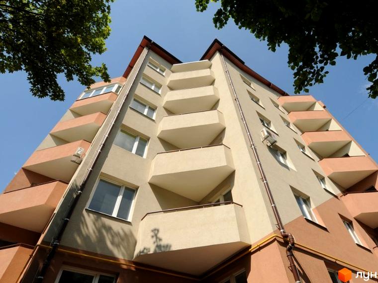 Житловий комплекс на вул. Чорнобаївська, 29. Вид на фасад будинку з балконами та прибудинкову територію з зеленими насадженнями.