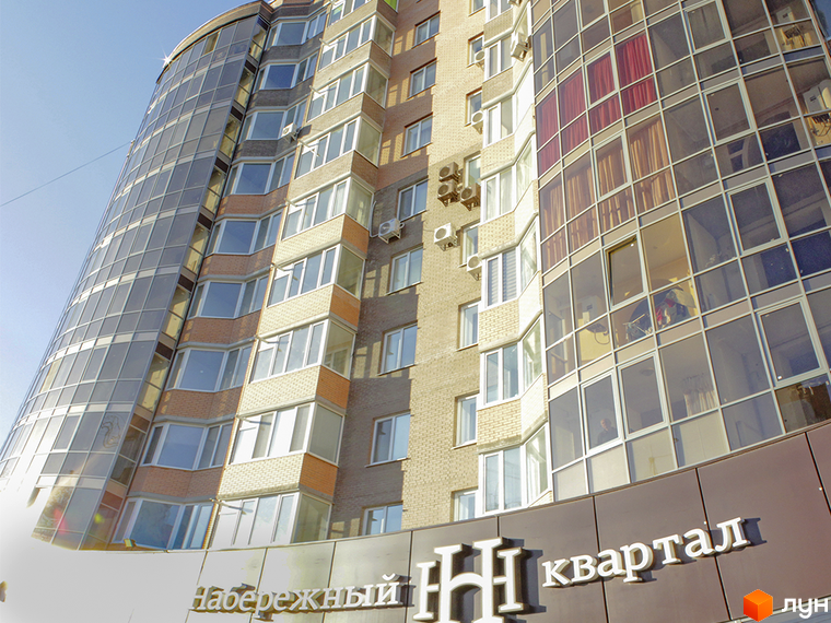 Зображення фасаду багатоповерхового будинку Житлового комплексу Набережний квартал. Вигляд новобудови з великими вікнами та скляними балконами.