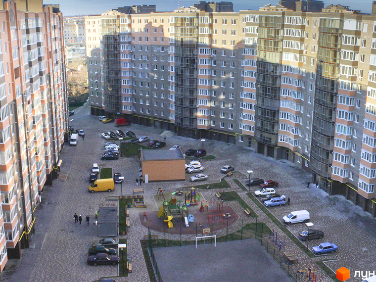 Житловий комплекс Набережний квартал: багатоповерхові будинки з великою прибудинковою територією, дитячим майданчиком, парковкою та спортивним майданчиком.