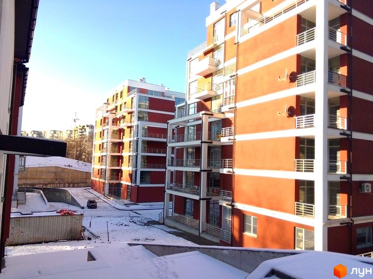 Зображення фасаду будинку в Житловому комплексі Золотий горіх. На фото видно прибудинкову територію взимку.