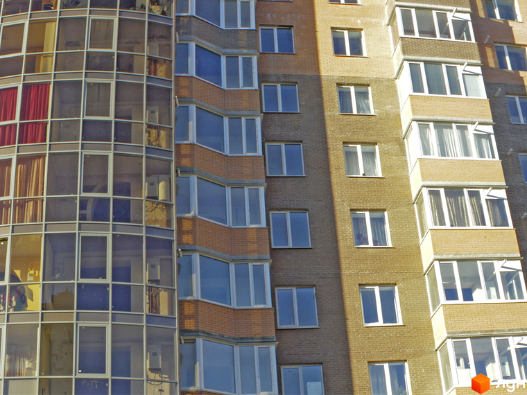 Зовнішній вигляд житлового району Набережний квартал. Багатоповерховий будинок з великими вікнами та балконами.