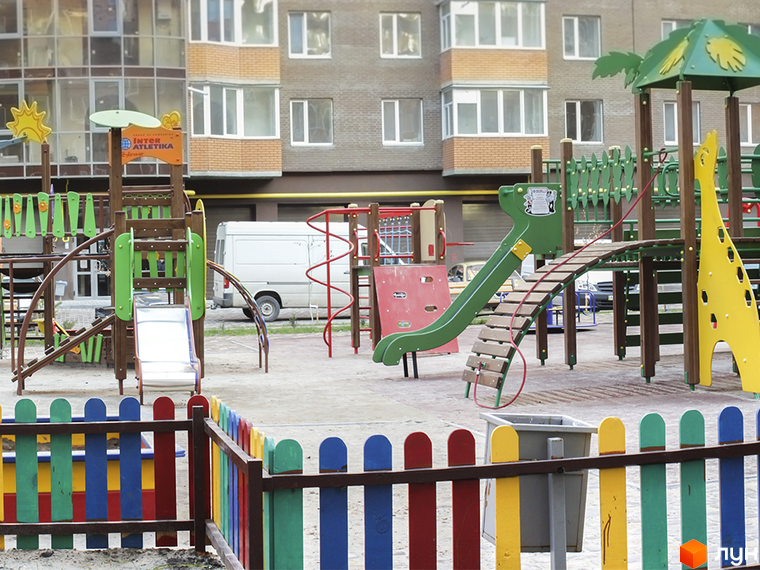 Майданчик для ігор з гірками та гойдалками біля Житлового комплексу Набережний квартал. Будинок з вікнами та прибудинкова територія.