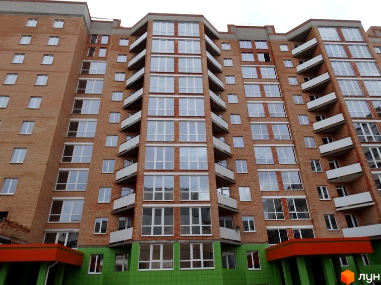 Зовнішній вигляд новобудови ЖК Адмірал Сенявін з цегляним фасадом та великими вікнами. Багатоквартирний будинок з балконами.