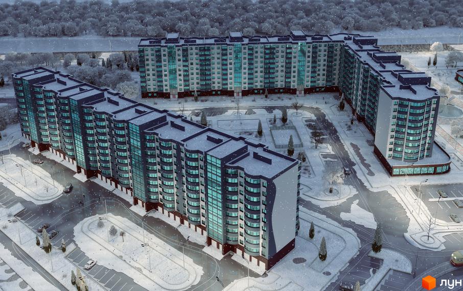 Зовнішній вигляд житлового комплексу Лазурний у зимовий період, з сучасними фасадами та великими вікнами. Навколо комплексу розташовані доглянуті прибудинкові території з парковками та деревами.