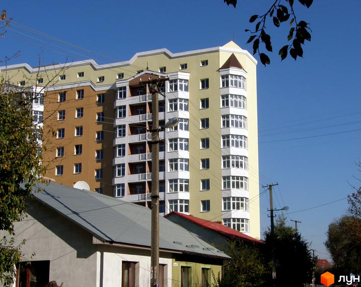 Зображення фасаду будинку на вулиці Варшавській, 193. Багатоповерхова будівля з великими вікнами та балконами на фоні блакитного неба.