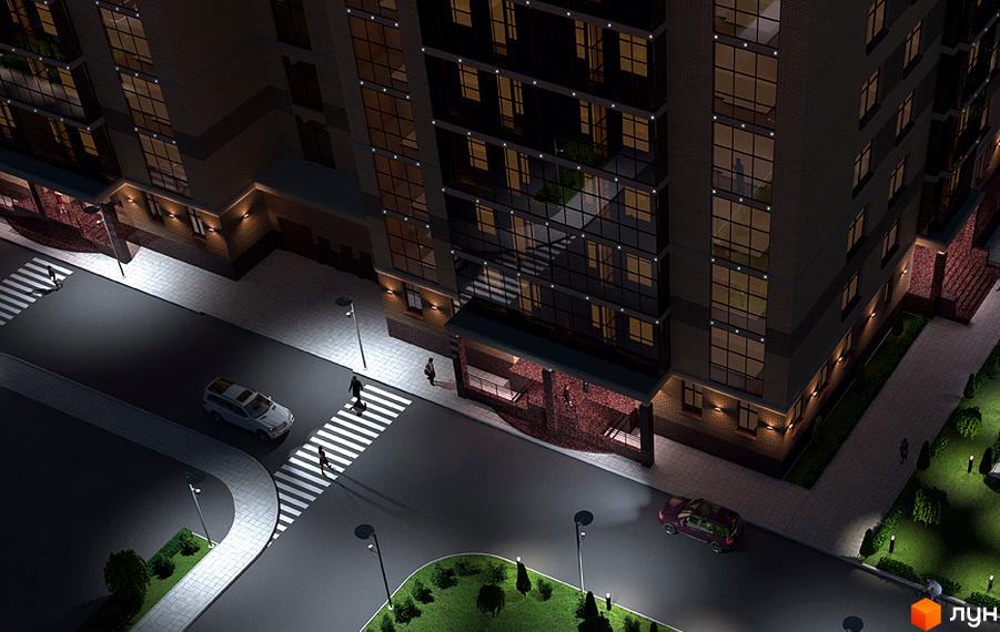 Новобудова ЖК Palladio з підсвіченими вікнами та вхідною групою, освітлена вулиця з пішохідним переходом та автомобілем.