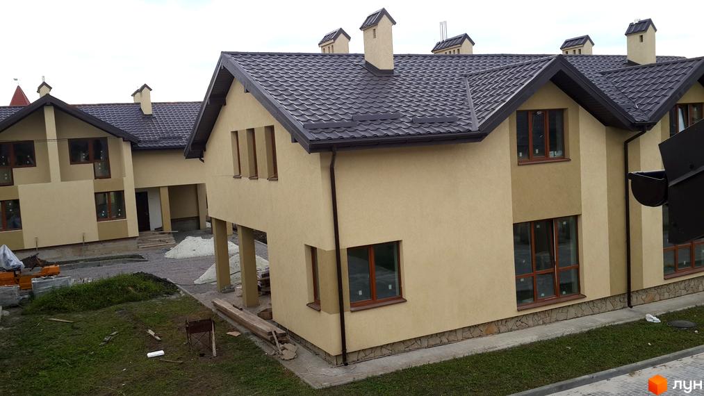 Двоповерхові будинки з бежевими фасадами, коричневими дахами та вікнами. Територія на вул. Бічна Івана Франка, 35-37, в процесі будівництва.