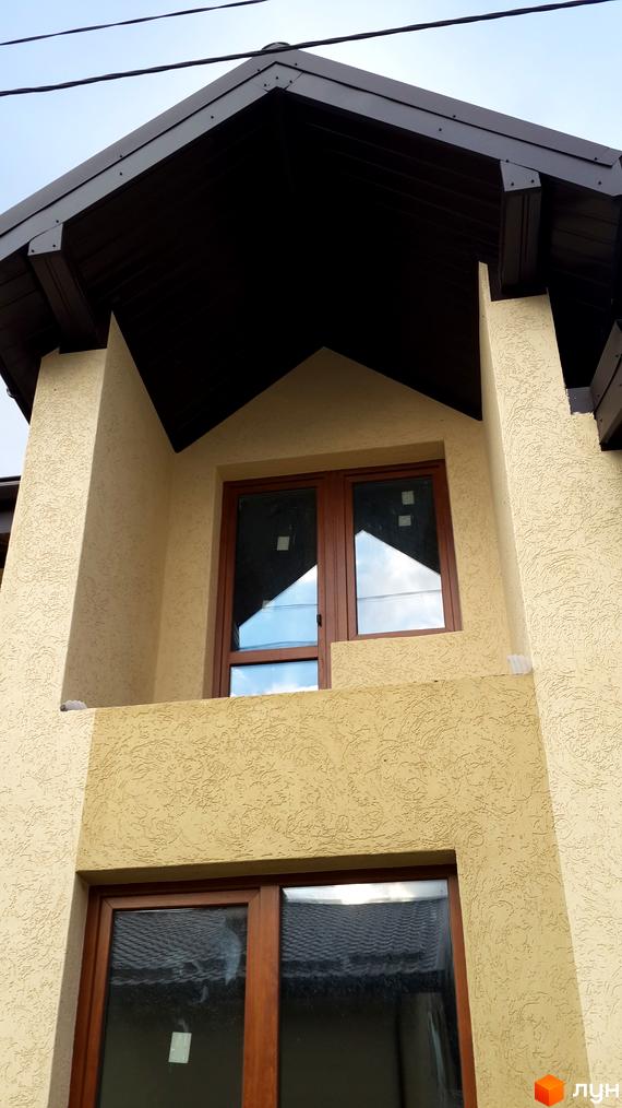 Фасад житлового комплексу на вул. Бічна Івана Франка, 35-37 з бежевою штукатуркою та коричневим дахом. Вікна мають коричневі рами.