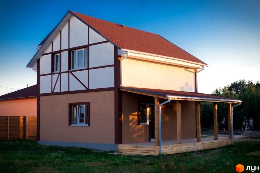 Двоповерховий будинок з фахверком, червоним дахом та дерев'яною терасою у Котеджному містечку HappyTown. Зелена ділянка.