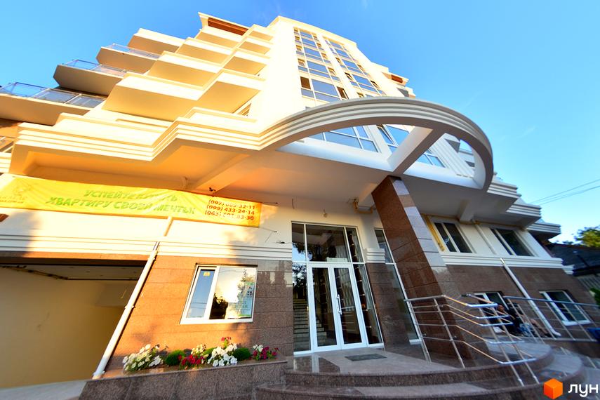 Сучасний житловий комплекс на вулиці Мала Морська, 2а. Зовнішній вигляд будівлі з балконами та панорамними вікнами, перед входом квіти та сходи.