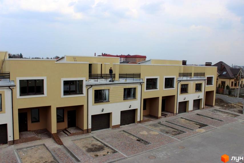 Зовнішній вигляд новобудови на вул. Кибалюка, 17. Прибудинкова територія з паркувальними місцями.