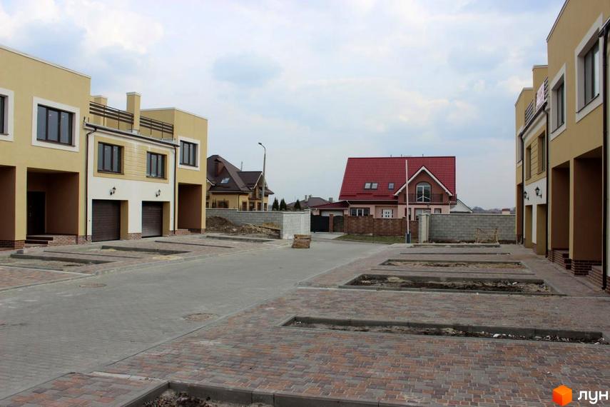 Новобудова на вул. Кибалюка, 17. Зовнішній вигляд будинків та прибудинкової території з бруківкою та паркомісцями.