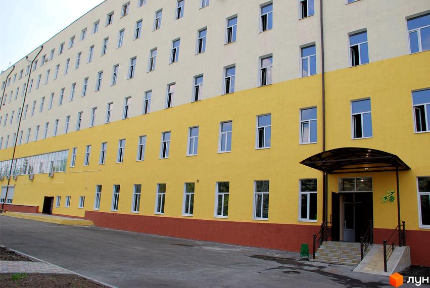 Новобудова Ялинковий двір має світлий верхній та жовтий нижній фасади з білими вікнами. Вхід обладнаний навісом, сходами та пандусом, поруч асфальтований під'їзд.