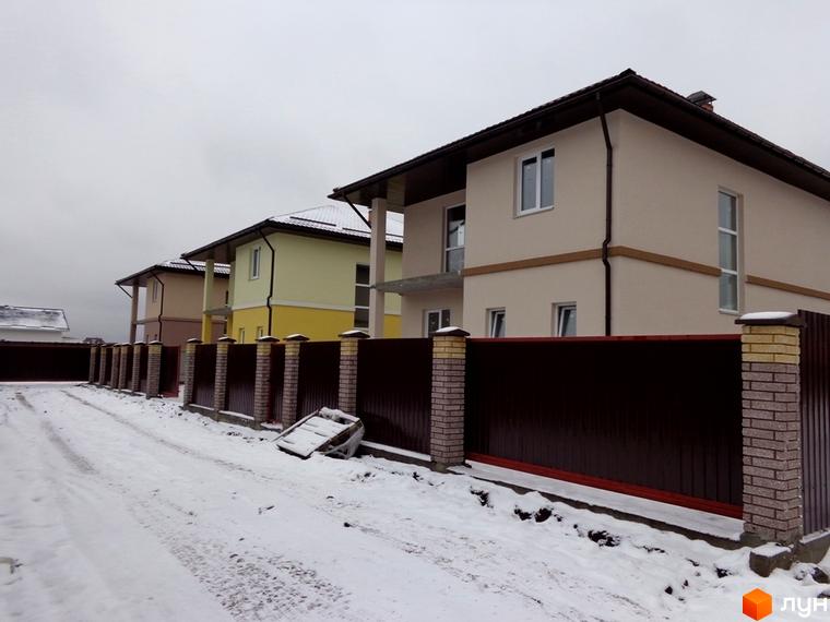 Котеджне містечко Village-Мархалівка: двоповерхові будинки світлих тонів. Засніжена територія з коричневим парканом та цегляними стовпами.