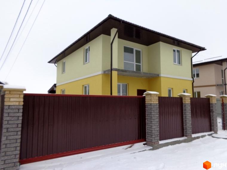 Фото двоповерхового будинку в Котеджному містечку Village-Мархалівка з коричневою огорожею та снігом навколо. Вигляд фасаду будинку.